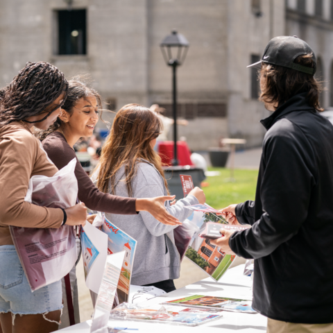 students at a table collecting flyers