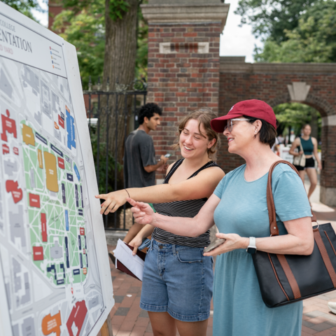 two people pointing at a map